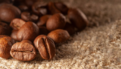 Roasted Black coffee beans on Burlap Sack background. Aroma ingredients. close up. coffee.