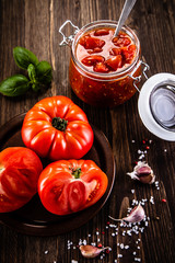 Raw tomatoes and tomato sauce in jar