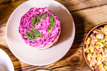 Set of festive mayonnaise salads on wooden table. Top view