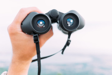 Male hand with binoculars outdoor, pov.