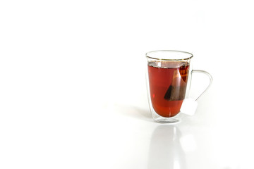 Tea in a glass mug with tea bag. Studio isolated on white background