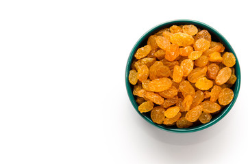 White or golden raisins in a blue ceramic bowl on a white background. Healthy eating concept. Top view. Closeup. Copy space