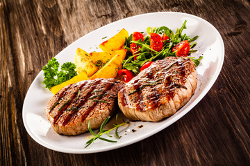 Grilled steak with baked potatoes and vegetables