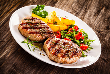 Grilled steak with baked potatoes and vegetables