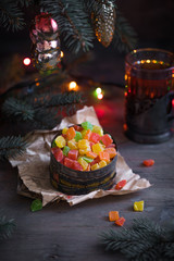 Vintage christmas box with candied fruits and peels on the old newspaper with fir tree branches