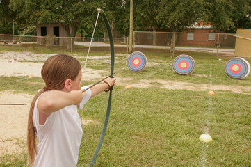 Girl using bow and arrow for archery