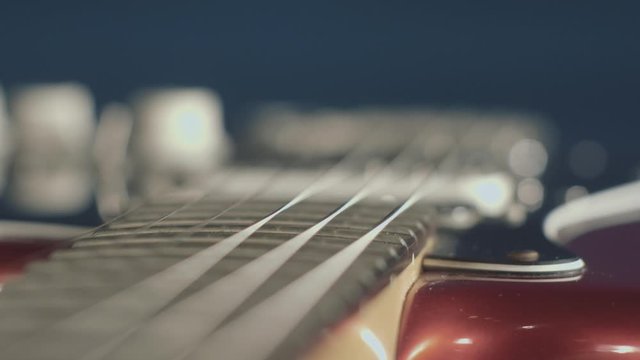 Extreme close up dolly shot of a red electric guitar body and neck