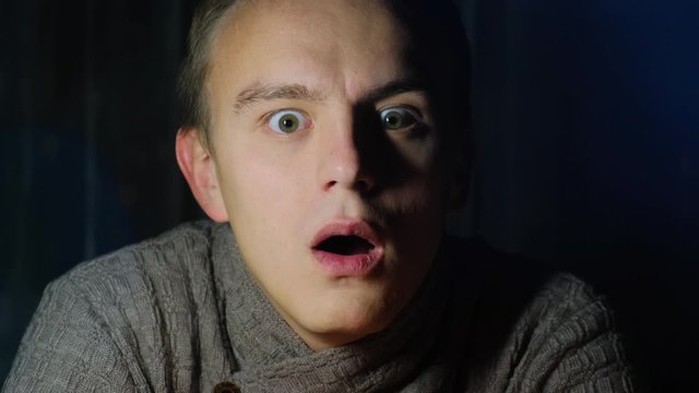 Face of astonished man watching action movie, close up