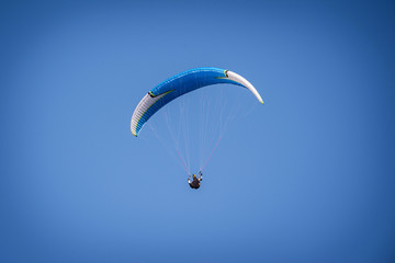 paraglider flying in the blue sky. Italian Alps. Piedmont. Italy