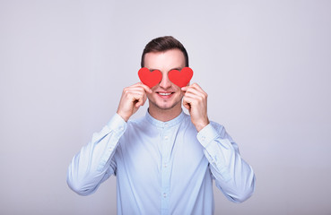 A sensitive guy in a blue shirt with two red hearts.