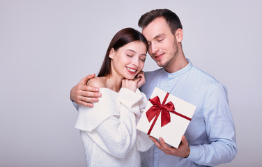 An elegant gentleman in a soft blue shirt acquired a lovely enchanted lady in a white knitted sweater