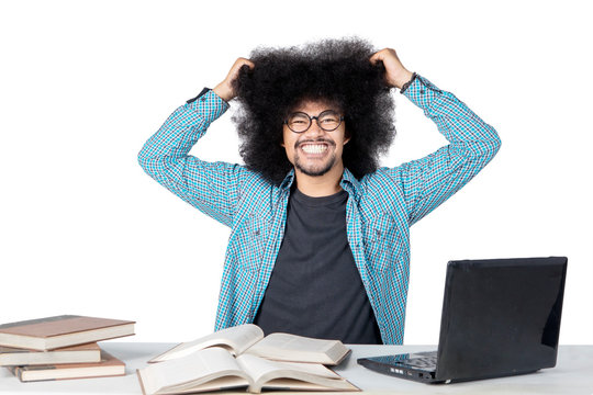 Stressed male college student pulls his hair while studying