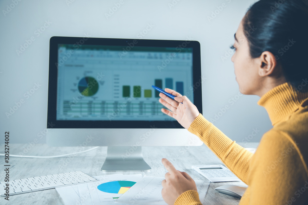 Poster woman working in computer with graph in office