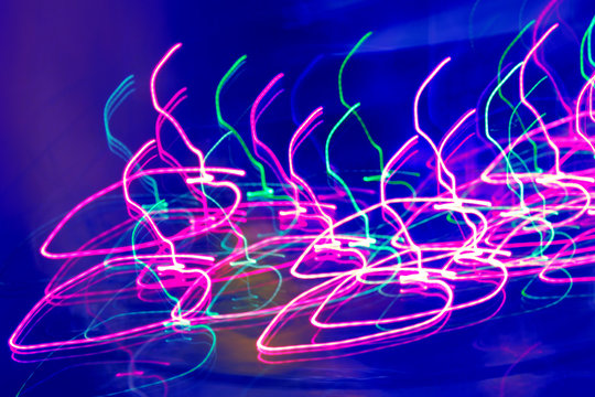 Creative photo with a neon pattern of dancing light. Randomly multi-colored lines on an abstract background. The concept of a unique desktop wallpaper or screen saver. Space, texture, blur.