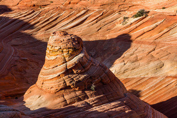 Cone shaped tower of layered sandstone in the Arizona desert of the Kaibab Plateau.
