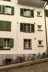 Many bicycles near the wall of the old house