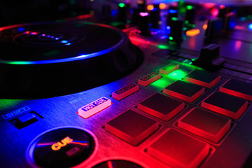 Fototapeta na wymiar Dj consolle, audio mixer, con luci colorate da discoteca