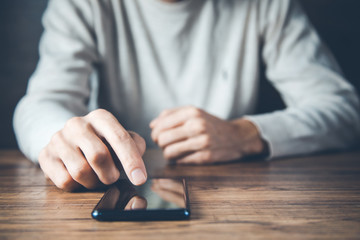 young man hand phone on desk