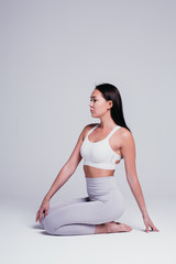 Sporty young woman doing yoga practice isolated on white background - concept of healthy life and...