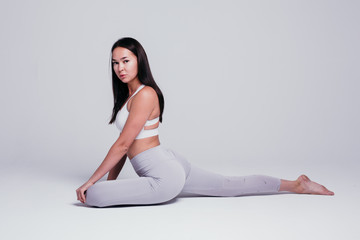 Fototapeta premium Sporty young woman doing yoga practice isolated on white background - concept of healthy life and natural balance between body and mental development
