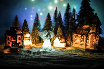 New Year miniature house in the snow at night with fir tree.