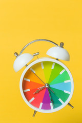 multi colored alarm clock flying isolated on a orange background abstract concept photography time flies 
