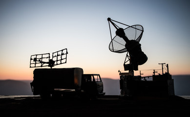 Satellite dishes or radio antennas against evening sky. Selective focus