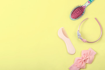 Little girl's hair accessories flat lay on bright yellow background with text space