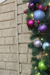 Christmas tree with balls on beige brick wall