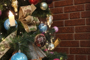 elegant Christmas tree with toys near the brown brick wall