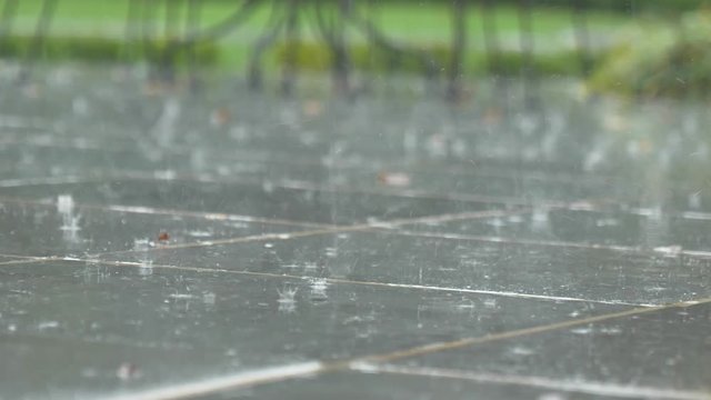 Rain falling on tile outside close up