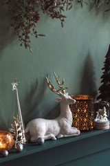Christmas composition on the shelf in the living room interior. Beautiful decoration. Christmas trees, candles, stars, light and elegant accessories. Merry Christmas and Happy Holidays, Template. 