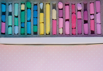 box with art soft pastel crayons on a pink background