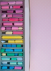 box with art soft pastel crayons on a pink background