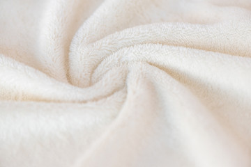 White delicate soft background of plush fabric plaid. Texture of beige soft fleecy blanket textile...