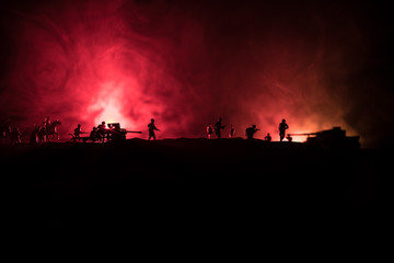 Fototapeta premium War Concept. Military silhouettes fighting scene on war fog sky background, World War German Tanks Silhouettes Below Cloudy Skyline At night. Attack scene. Armored vehicles and infantry.