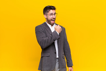 young handosme man feeling happy, positive and successful, motivated when facing a challenge or...