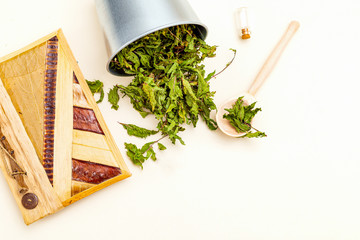 Dried mint, wooden spoon and notebook on a white background. Healthy lifestyle. Copy space