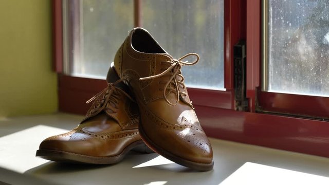 Slow reveal of brown shoes in window
