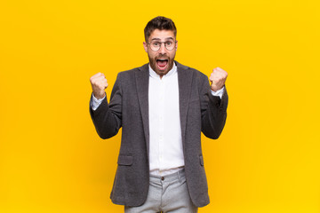 young handosme man shouting aggressively with an angry expression or with fists clenched...