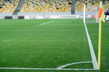 Corner flag and green lawn view. Football game. Stadium