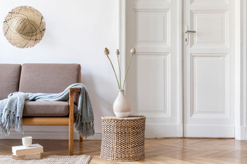 Stylish and cozy interior of living room with design brown sofa and elegant rattan accessories. Korean beige style of home decor. Minimalistic concept of interior design. Template. 