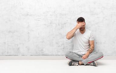 young handosme man covering eyes with one hand feeling scared or anxious, wondering or blindly...