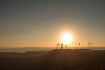 molinos de vientom a contraluz con el atardecer