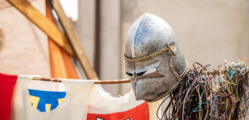 fake knight helmet on medieval reconstruction festival blurred unfocused background 