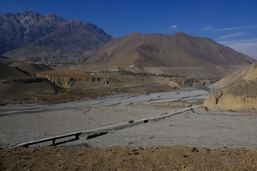 Road bridge in the Kaali Gandaki valley in the amazing land of Mustang in the Himalaya in Nepal, near Lupra. This is the deepest valley in the world. During Annapurna Circuit trekking.