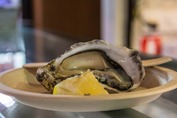 Fresh raw open oyster with lemon on a plate
