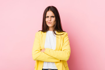 Young business woman frowning face in displeasure, keeps arms folded.