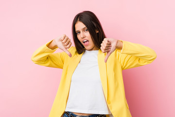 Young business woman showing thumb down and expressing dislike.