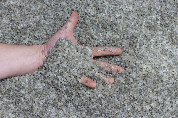 Hand on background of recycled plastic granules for plastic bag production
